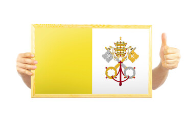Hands holding a frame with Vatican flag, two hands and thumb up, approvement or success in Vatican