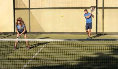 Mature Couple Playing Padel Tennis at Sunset