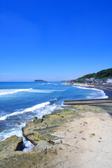 サーファーが波と戯れる夏真っ盛りの鎌倉の海と、美しい江ノ島の風景