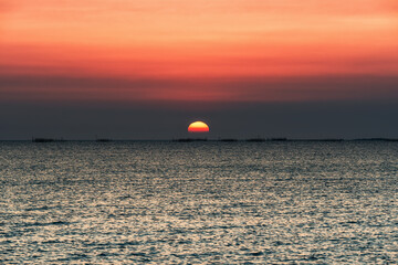 Sunset over the sea background. Big sun over the sea with beautiful natural light at sunset or sunrise.