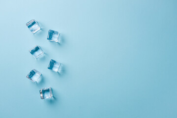 top view of ice cubes of different sizes on blue background
