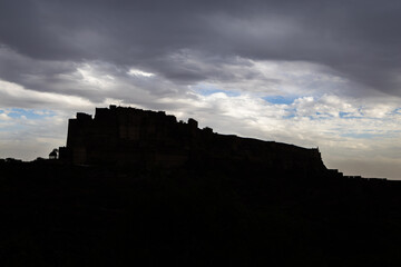 backlit shot of ancient historical fort with dramatic cloudy sky at evening from different angle