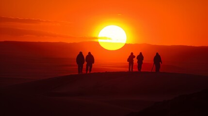 People silhouttes in desert watching big sun going down during epic sunset