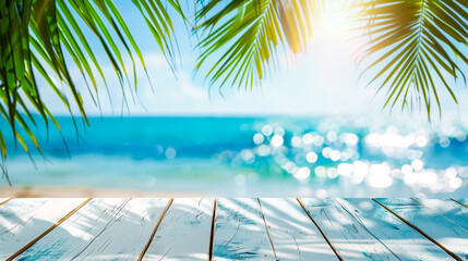 Tropical beach view with sun gleaming through green palm leaves, showcasing a serene ocean and clear blue sky, viewed from a white wooden deck.