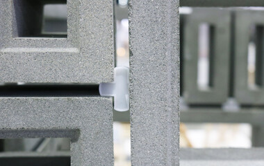 Close-up concrete ventilation block with joint gap support.