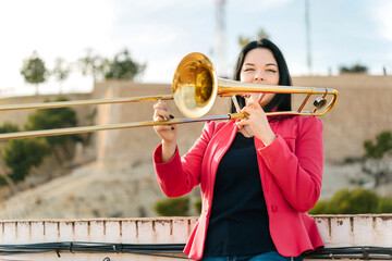 Young girl trombonist playing cheerful