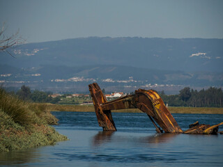 abandoned rusted bulldozer in Aveiro lagoon Ria de Aveiro located on the Atlantic coast of Portugal