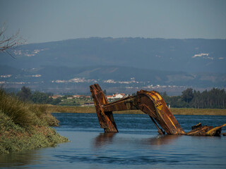 Naklejka premium abandoned rusted bulldozer in Aveiro lagoon Ria de Aveiro located on the Atlantic coast of Portugal