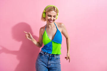 Photo of optimistic girl with bob hairdo dressed colorful tank in headphones dancing relaxing on...