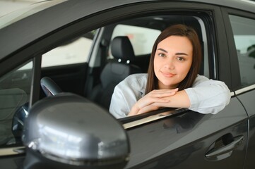 Beautiful young female client customer choosing new car