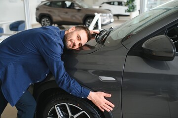 Young man is choosing a new vehicle in car dealership