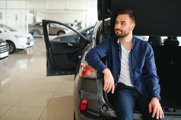 Man customer male buyer client chooses auto wants to buy new automobile