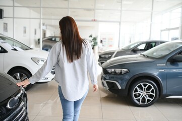 Happy friendly woman customer female buyer client chooses auto wants to buy new automobile