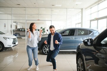 Excited Spouses Dancing In Dealership Office After Buying New Car