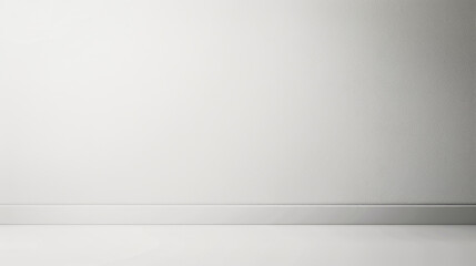 A white wall with a white baseboard. The wall is bare and empty