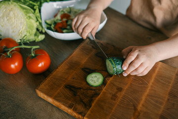 Child at table with leaf vegetables, a natural food ingredient