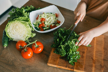 Child at table with leaf vegetables, a natural food ingredient