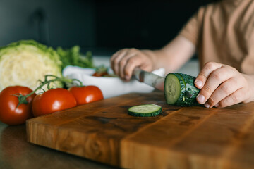 Child at table with leaf vegetables, a natural food ingredient