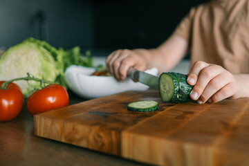 Child at table with leaf vegetables, a natural food ingredient