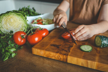 Child at table with leaf vegetables, a natural food ingredient