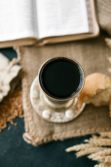 Cup with wine, bread and open Bible, Christian communion