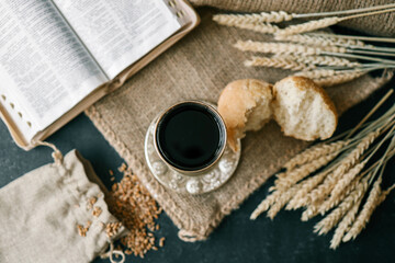 Cup with wine, bread and open Bible, Christian communion