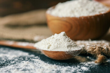 Flour in a wooden bowl on burlap