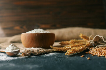 Flour in a wooden bowl, fresh homemade bread and ears of corn, bakery banner