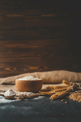 Flour in a wooden bowl, fresh homemade bread and ears of corn, bakery banner