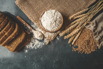 Flour in a wooden bowl, fresh homemade bread and ears of corn, bakery banner