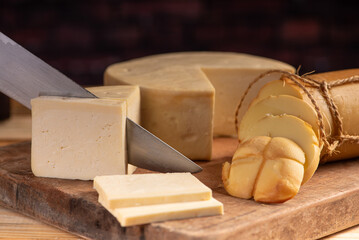 Cheese, details of beautiful and delicious cheese on rustic wooden surface, selective focus.