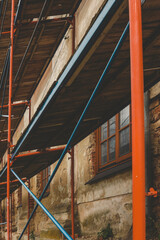 Scaffolding on a generic old tenement house, renovated historical building facade detail, closeup,...