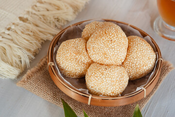 Onde-onde Sesame Seed Balls, filled with peeled green beans. Served on a wooden plate Close Up. Popular Indonesian Snacks