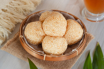 Onde-onde Sesame Seed Balls, filled with peeled green beans. Served on a wooden plate Close Up. Popular Indonesian Snacks