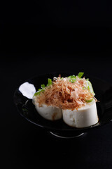 Japanese tofu Japanese appetizer soft cold tofu with sauce ginger and green onion topping isolated in black background