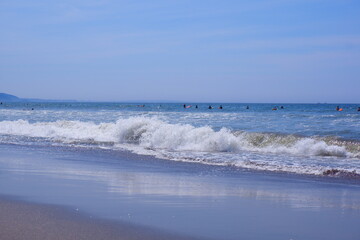 きらきら輝く夏の海で、サーファーがサーフィンを楽しむ夏のイメージ
