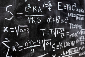 Operaciones matemáticas y formulas de física cuántica escritas a mano con una tiza en la pizarra	