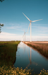 wind turbines in the field near the canal