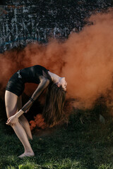 Girl doing back bend outdoors. 
Girl doing a back bend in front of the tunnel 