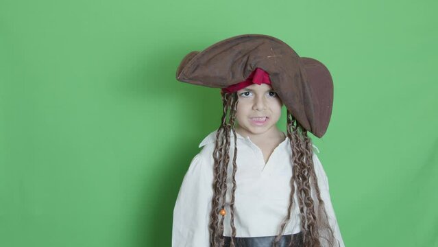 Cute child pirate taking cutlass and slicing through the air solated on green screen. High quality 4k footage