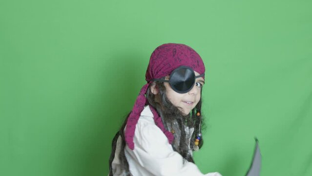 Cute child pirate taking cutlass and slicing through the air solated on green screen. High quality 4k footage