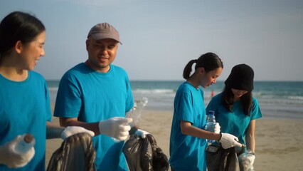 Volunteer people group in volunteering charity activities cleaning up waste plastic on sand sea ocean beach. Corporate social responsibility and society activity for Environment . Ecology and CSR.