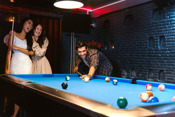 Young diversity group of people playing pool together with smile, enjoyment and fun. Young people...