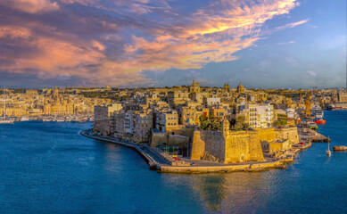 Dusk over the fortified sea front of Birgu (Cospicua), Grand Harbour, across from the old town of...