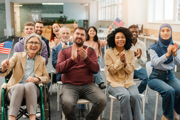 Group of smiling, multinational people, US citizens holding American flag, applauding, meeting