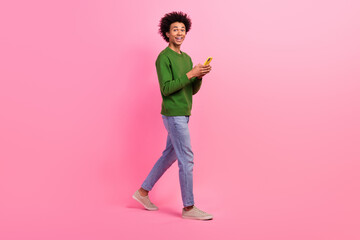 Photo of excited positive guy walking using cellphone navigate route with geo app isolated pastel color background