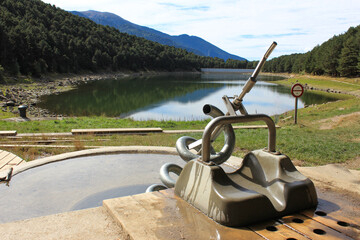 Ancient devices and devices for moving water against the backdrop of a mountain lake
