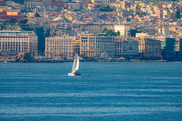 Sailing in the harbor of Naples, (Napoli), Campania, Italy. the historic city center can be see in...