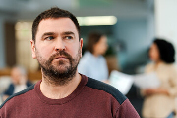 Portrait of pensive middle aged bearded man, manager, employee looking away