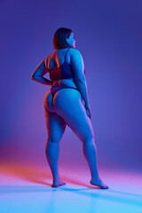 Full-length back view image of young girl posing in underwear, with plus size body shape against...